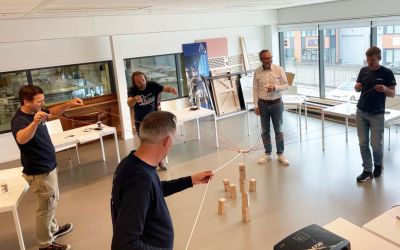 Een groep mensen doen een oefening verbinden in een kantooromgeving.